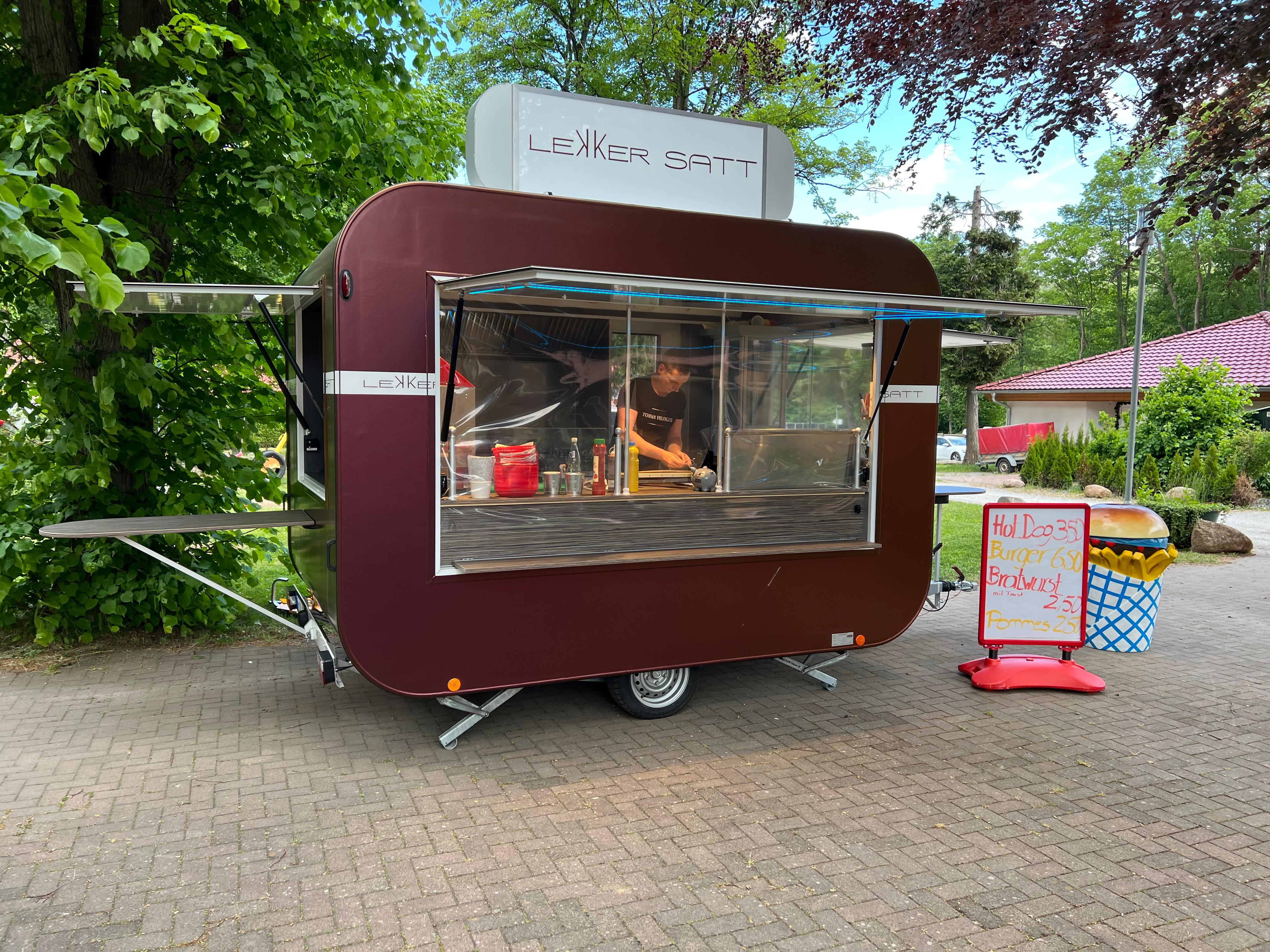 Lekker Satt Food Trailer im Betrieb mit Werbetafel